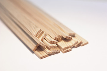 Pile of miniature wooden planks on white background