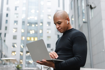 Smiling young african man standing in the city street