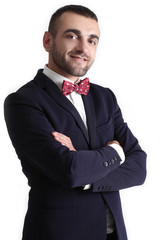 Confident young man in jacketwith bowtie standing with hands in pockets