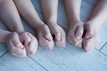 Fototapeta premium Six children's hands clenched into fists. On a wooden background.
