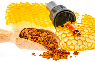 propolis tincture and a wooden spoon of propolis granules