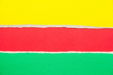 Red, green and yellow torn cardboard paper background with copy space for text message.