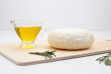 Round white cheese, sour milk, decorated with rosemary and olive oil, two ripe pears. The concept of types of cheese or dairy products rich in calcium.