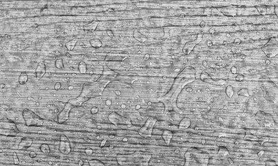 Water drops on a wooden floor surface.Drop of water on wood with raindrop after a rain with copy space.