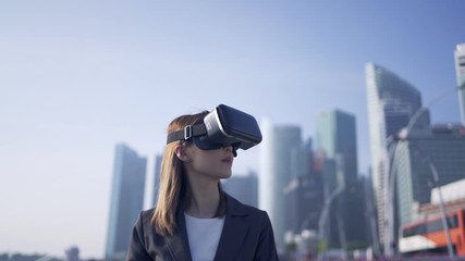 Future is now. Woman using virtual reality device while traveling in Singapore .  - Powered by Adobe