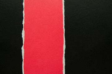 Torn red cardboard on black paper texture background. Copy space for text message.