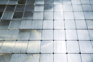 shiny steel machined blocks pavement surface background - close-up with selective focus and blur