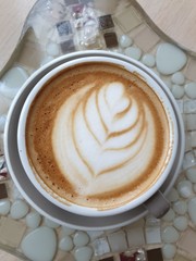 cup of coffee with cream on wooden background