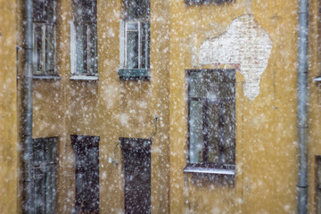 facade of an old yellow house in heavy snow before a storm
