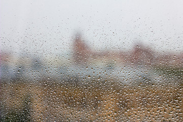 water drops after rain on glass on a blurred background of urban houses