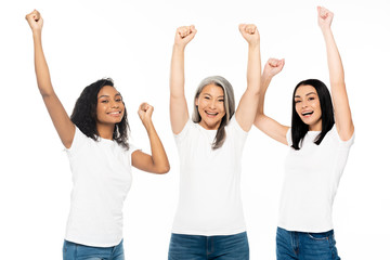 excited multicultural women with hands above head celebrating isolated on white