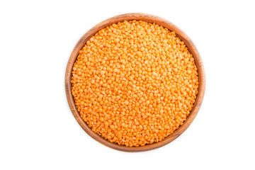 Raw uncooked lentils in a wooden bowl isolated on white background. Top view.