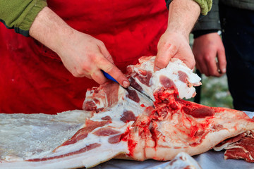 A butcher cuts pork