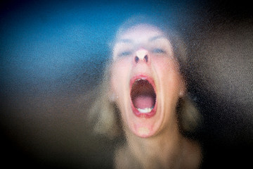 woman screaming through frosted glass