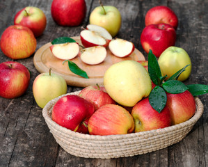 Basket with apples on wooden background.