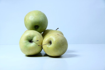 a pile of green apples isolated on light background