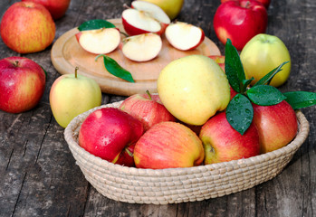 Basket with apples on wooden background.