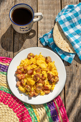 Scrambled eggs with sausage breakfast on wooden background