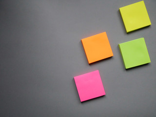 Collection of different colored sheets of note papers ready for your message. Isolated on gray background. Front view.