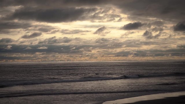 Surfers on waves at golden hour, beautiful sunset on the beach