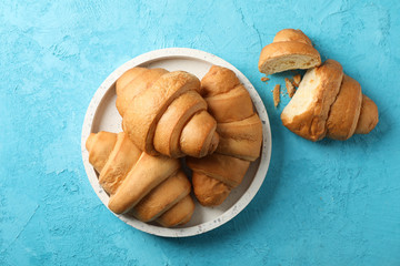 Tray with croissants on blue background, top view