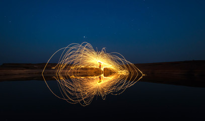 Amazing Fire Show at night .The fire show and a lot of the bright sparks in the night.Play a beautiful and exciting fire.Dark light. panorama view .