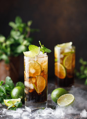 Cuba Libre with brown rum, cola, mint and lime. Cuba Libre or long island iced tea cocktail with strong drinks