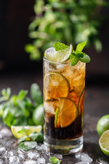 Cuba Libre with brown rum, cola, mint and lime. Cuba Libre or long island iced tea cocktail with strong drinks