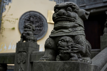 Fototapeta na wymiar Chongqing, China - March 21, 2018: Sculptures on the railing near the entrance to the ancient Buddhist monastery in the chinese city of Chongqing.