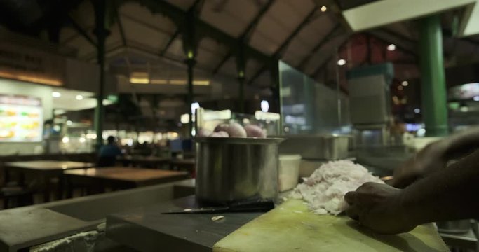 indian hawker cutting onions at his stall at lau pau sat