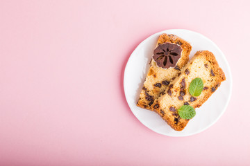 Homemade cake with raisins and dried persimmon on a pink pastel background. Top view, copy space.
