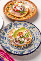 Mexican ham toast also called tostadas with beans and cheese on white background