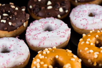 Decorated Donuts or Doughnuts Flat Lay on Dark Background