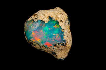 macro mineral stone rare and beautiful opals on a black background