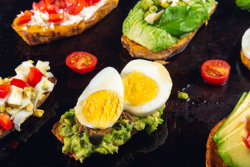 Sweet potato toasts with avocado, eggs, tomatoes and sesame seeds