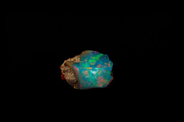 macro mineral stone rare and beautiful opals on a black background