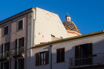 Fototapeta na wymiar Street and a dome of a church, Alghero, Italy