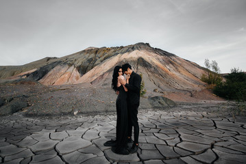 An Asian couple in love in black leather clothes walk in nature among the trees. Style, fashion, love