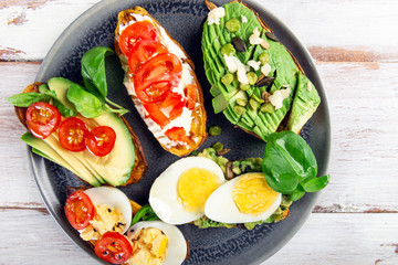 Sweet potato toasts with avocado, eggs, tomatoes and sesame seeds