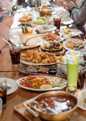 Fototapeta na wymiar Various kind of gourmet food and drink with family eating on wooden table