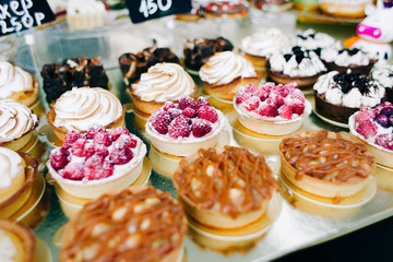 a lot of beautiful delicious cakes with nuts and berries at the street fair