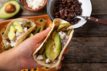 Mexican grilled nopal cactus tacos with cheese and avocado on wooden background