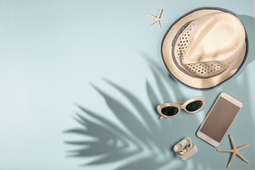 Summer holiday concept on light blue background with shadow, flat lay