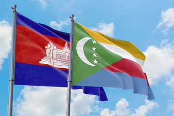 Comoros and Cambodia flags waving in the wind against white cloudy blue sky together. Diplomacy...