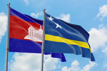 Curacao and Cambodia flags waving in the wind against white cloudy blue sky together. Diplomacy...