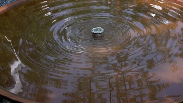 Wasser sprudelt aus einer D&uuml;se in ein Becken