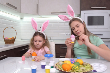 Happy easter. Two sisters painting Easter eggs. Happy family children preparing for Easter. Cute little child girl wearing bunny ears on Easter day.