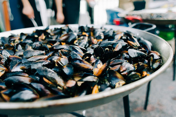 delicious oysters cooked in a large frying pan in a creamy tomato sauce at a street market