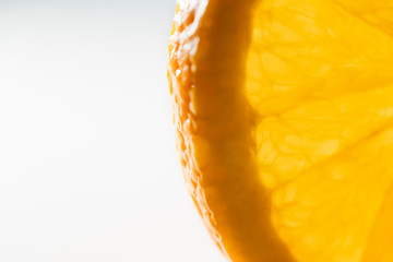 Large orange fruit slice isolated on white background, close up. Extreme close up, color image with...