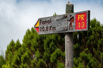 Obraz premium A sign indicating the direction and distance of the Hiking route.